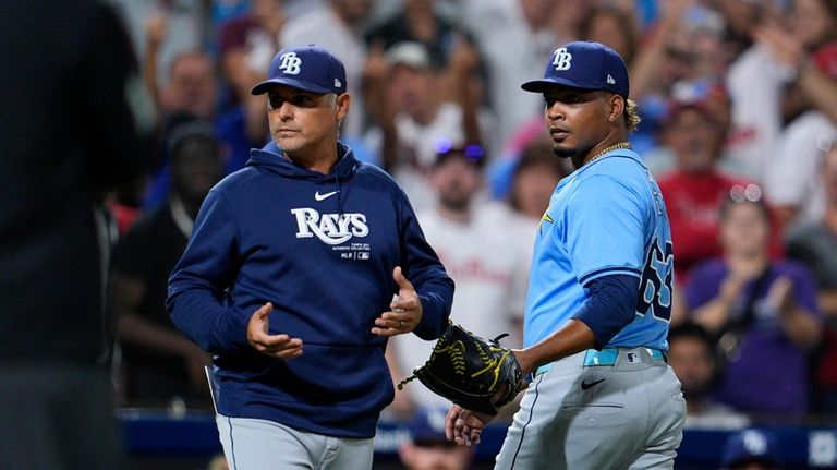 Tampa Bay Rays' Edwin Uceta, right, walks off the field...