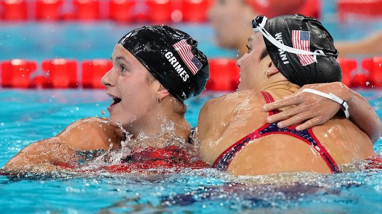 Katie Grimes, left, of the United States embraces compatriot Emma...