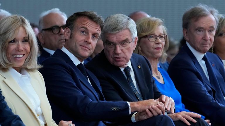 IOC President Thomas Bach, center, French President Emmanuel Macron, center...