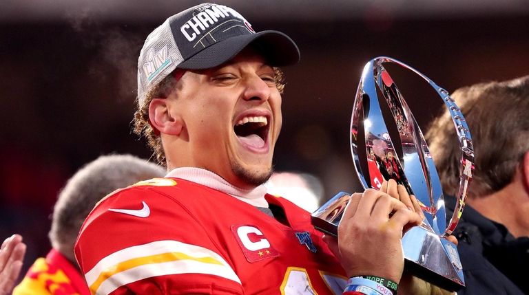 Patrick Mahomes of the Chiefs holds up the Lamar Hunt trophy...