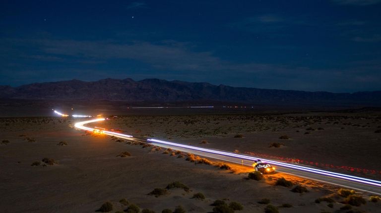 This long exposure image shows the path of runners and...