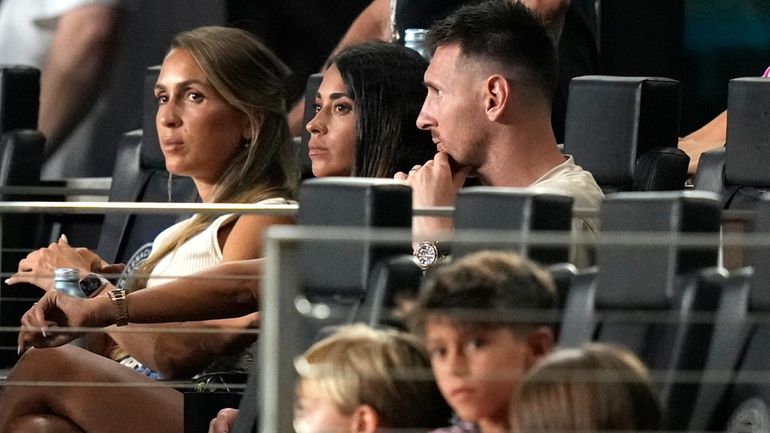 Inter Miami forward Lionel Messi, top right, sits with his...