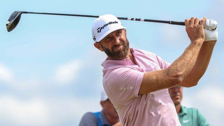 Dustin Johnson of the United States hits off the 13th...