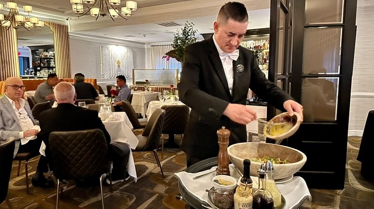 A captain prepares Caesar salad, tableside, at Il Mulino New...