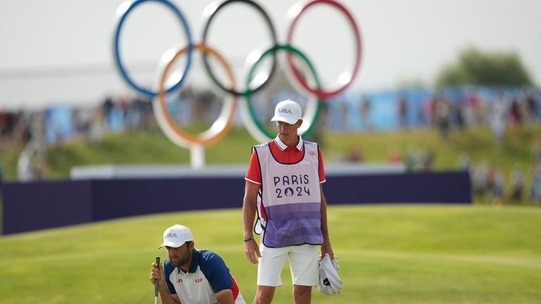 Scottie Scheffler, of the United States, looks at his putt...