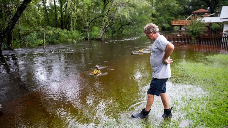 Gene Taylor watches the flood waters around his house in...