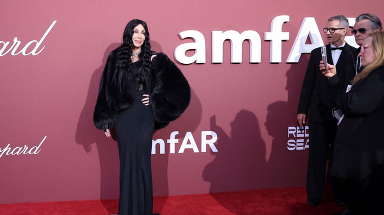 Cher poses for photographers upon arrival at the amfAR Cinema...