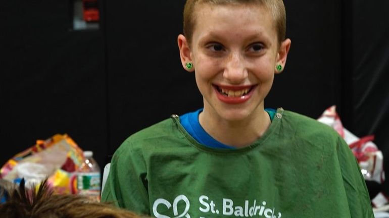 Madison Adelman, 11, had her head shaved in support of...