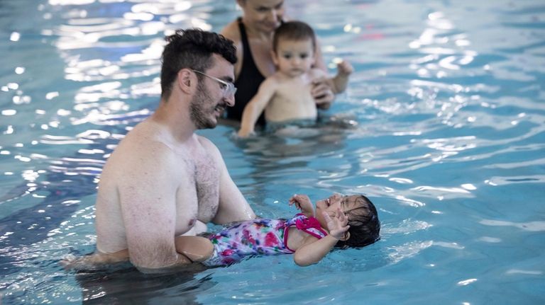 Justin Drago and his daughter, Sofia, 1, learn swim safety at...