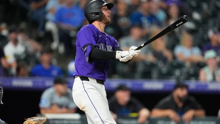 Colorado Rockies' Ryan McMahon follows the flight of his solo...