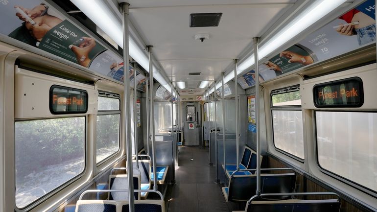 A Chicago Transit Authority Blue Line train car rides empty...