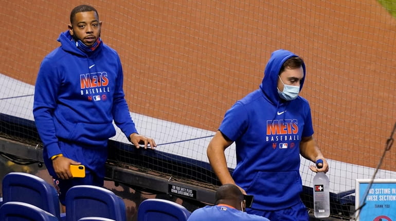Mets players walks to the dugout before a game against...