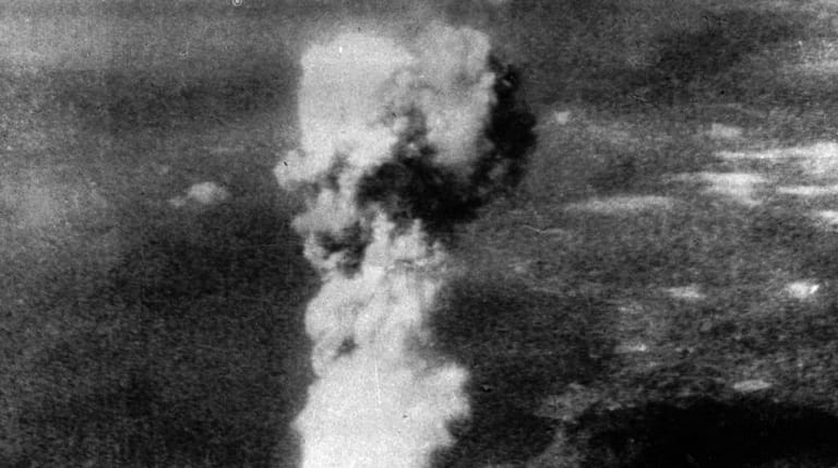 A column of smoke rises 20,000 feet over Hiroshima, Japan,...