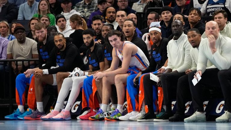 Oklahoma City Thunder guard Josh Giddey, center, sits on the...