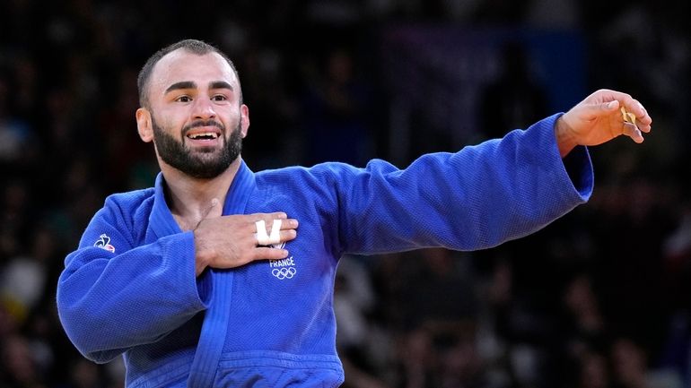 France's Luka Mkheidze celebrates after defeating Turkey's Salih Yildiz during...