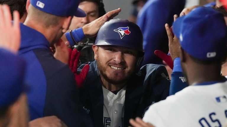 Toronto Blue Jays' Alejandro Kirk celebrates in the dugout after...