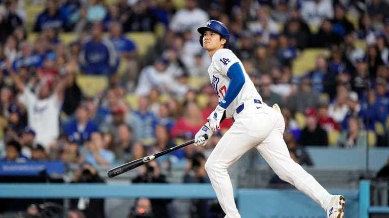 Los Angeles Dodgers designated hitter Shohei Ohtani heads to first...