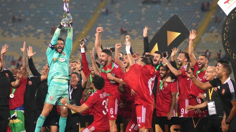 Al Ahly players celebrate with the trophy after winning the...