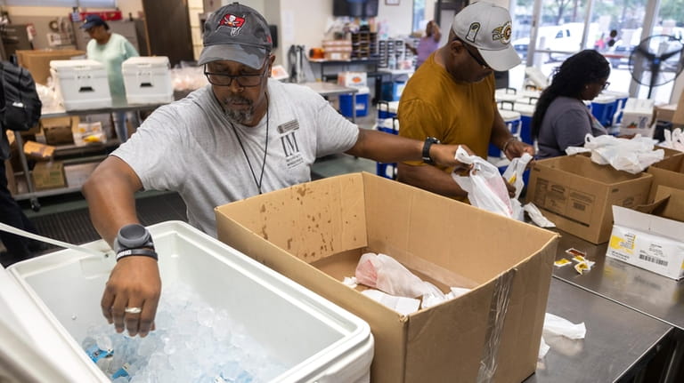 Warehouse Specialist David Callwood grabs cold cartons of milk for...