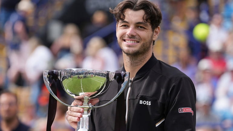 Taylor Fritz of the US celebrates with the trophy after...