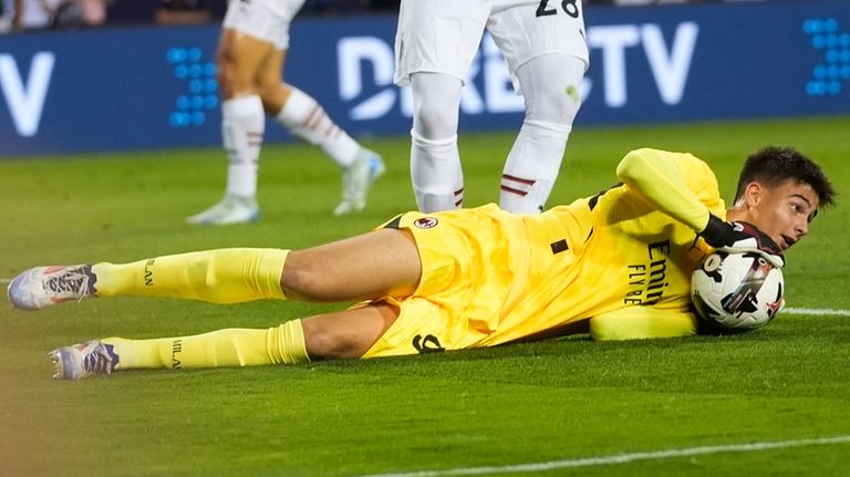 AC Milan goalkeeper Lorenzo Torriani makes a save against Real...