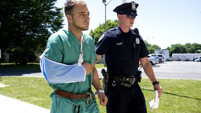 Matthew J. Byank of Manorville, is escorted into East Hampton...