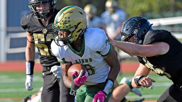 Longwood's Tyson Taylor runs past Commack defender Richard Schuld at Commack...