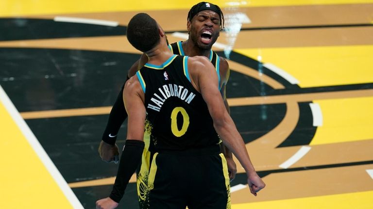 Indiana Pacers' Tyrese Haliburton (0) and Buddy Hield, right, celebrate...