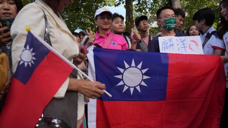 Fans display flags of Taiwan as they cheer outside Porte...