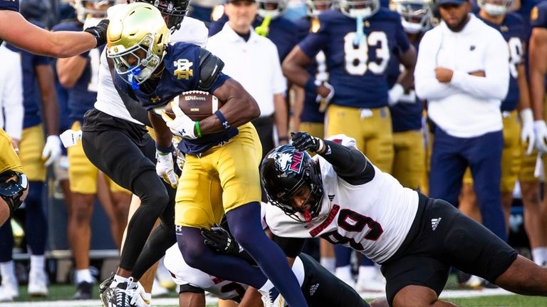 Notre Dame wide receiver Beaux Collins, front left, tries to...