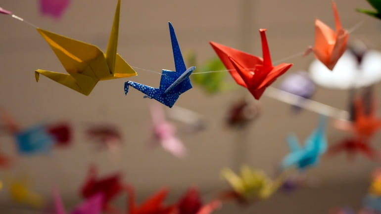 Strings of origami cranes decorate the entry hall in The...