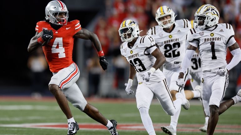 Ohio State receiver Jeremiah Smith, left, outruns the Western Michigan...