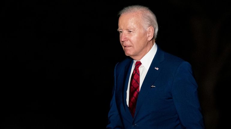 President Joe Biden walks across the South Lawn of the...