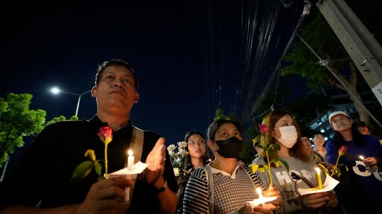 Thai activists hold candles during a vigil for Netiporn Sanesangkhom,...