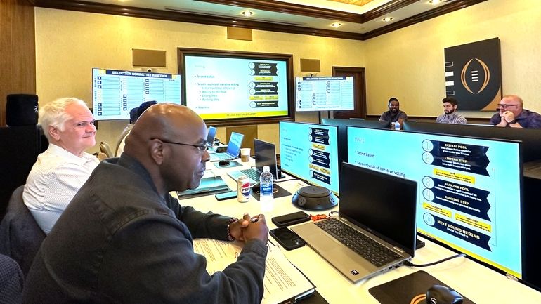 Media members and others participate in a mock College Football...