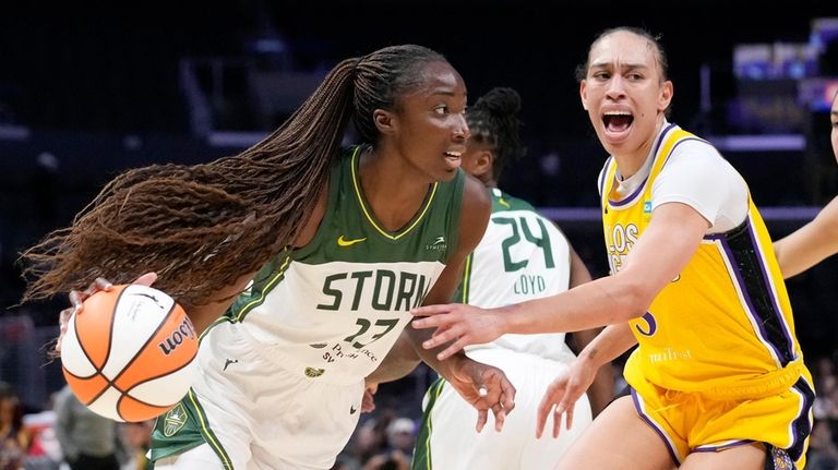 Seattle Storm center Ezi Magbegor, left, drives by Los Angeles...