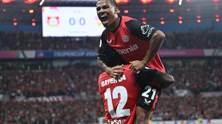 Leverkusen's Edmond Tapsoba, left, Amine Adli cheer during the German...