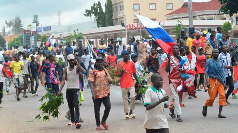 People wave Russian flags during a protest in Kaduna, Nigeria,...