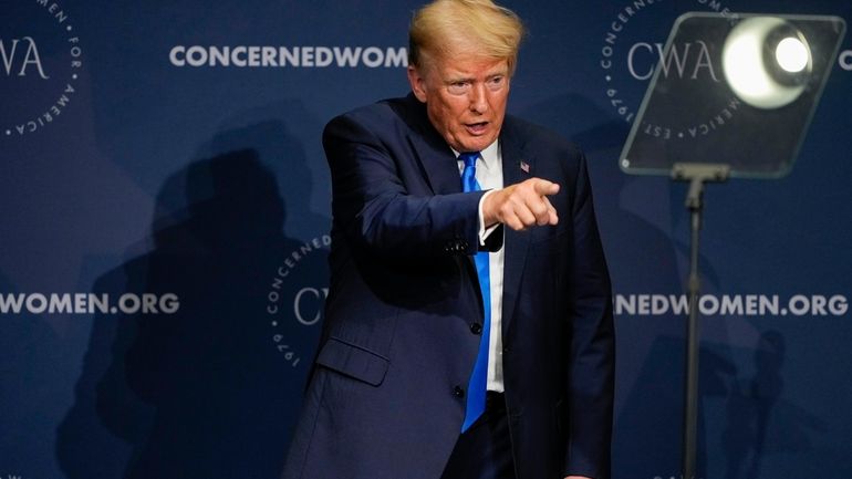 Former President Donald Trump points to the crowd after speaking...