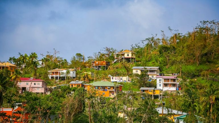 Roofs of houses lie damaged by Hurricane Beryl in St....