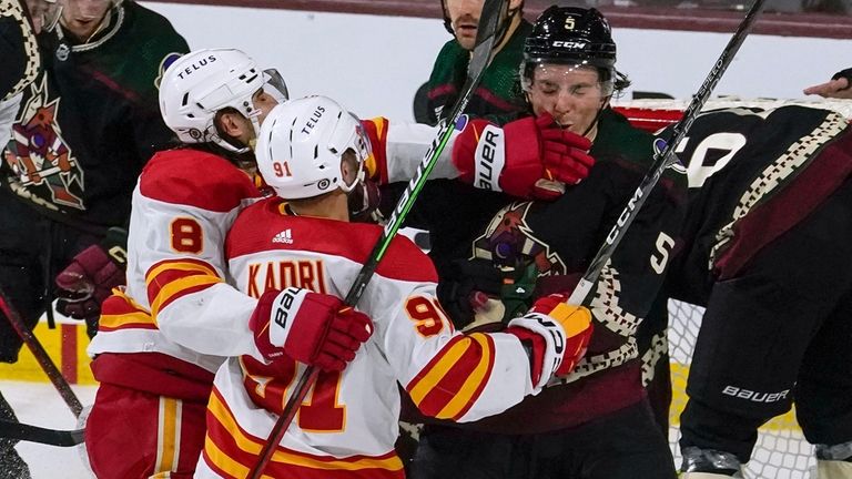 Calgary Flames' Chris Tanev (8) and Nazem Kadri (91) fight...