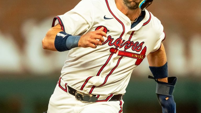 Atlanta Braves' Whit Merrifield rounds second base after a hit...