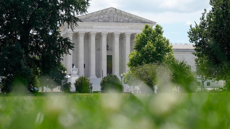 The U.S Supreme Court is viewed from the lawn of...