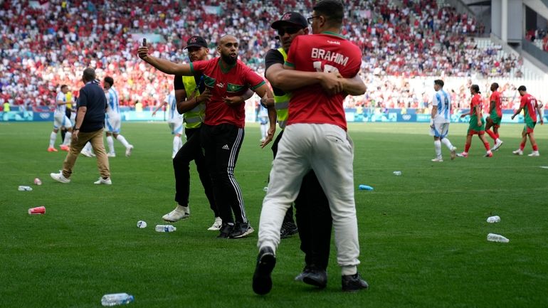 Stewards catch pitch invaders during the men's Group B soccer...