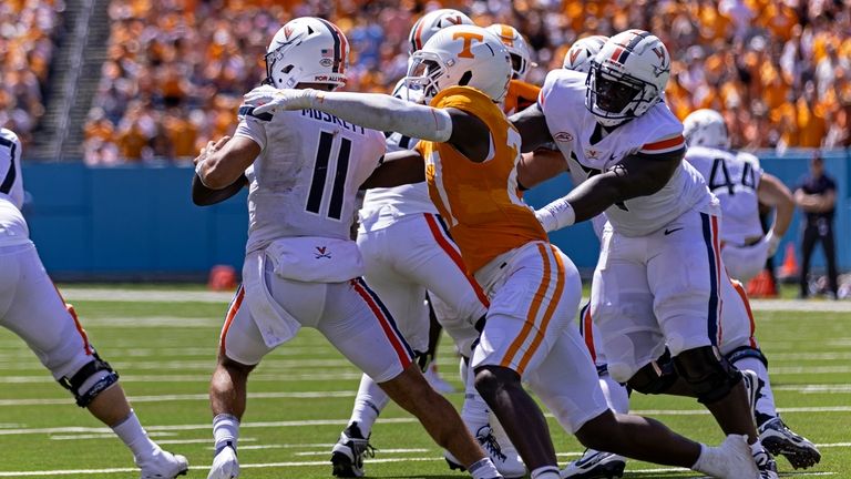 Virginia quarterback Tony Muskett (11) is pressured by Tennessee defensive...