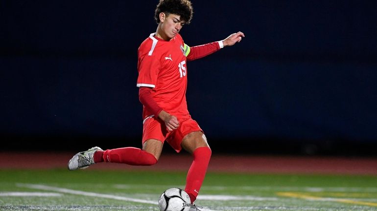 Mineola's Sebastian Knight takes a free kick during a Class...