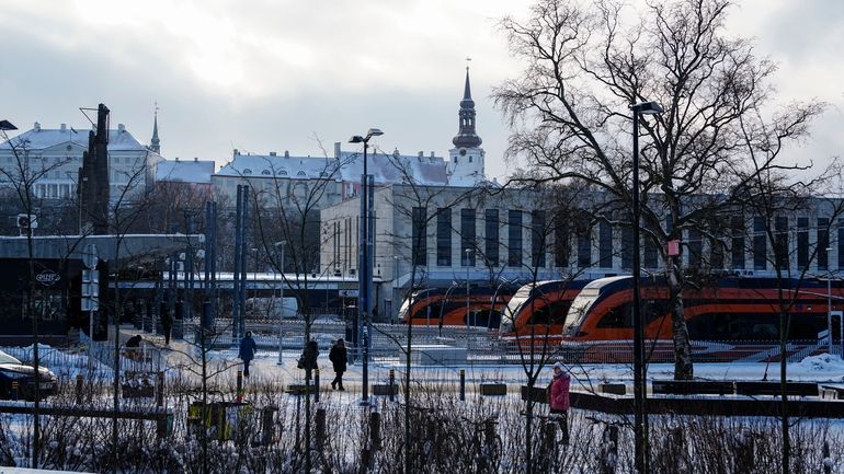 People walk at Baltic train station, with the Stenbock House,...