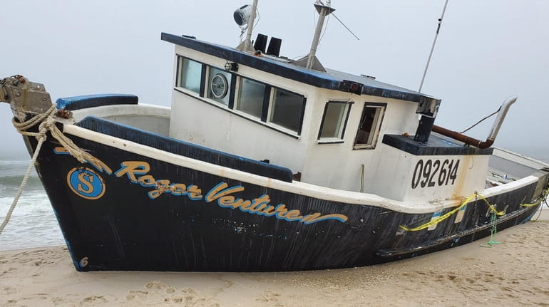 The fishing boat Roger Ventures rests on the sand at Jones Beach...