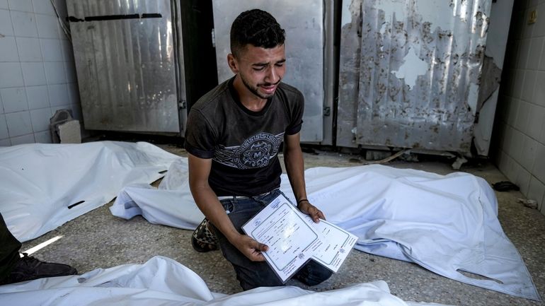 A Palestinian man mourns his 4-day-old twin relatives, killed in...