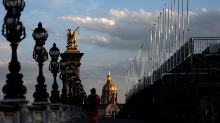 The sun sets against the Hotel des Invalides as a...